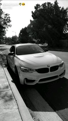 a white car is parked on the side of the road