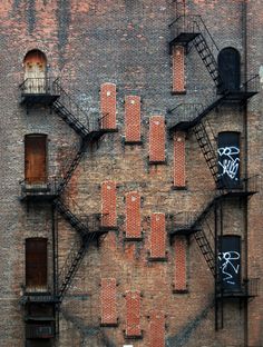 an old brick building with lots of windows and graffiti on the side, as seen from above