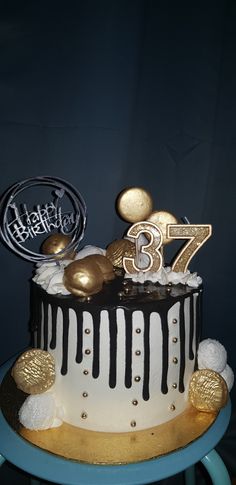 a white and black cake with gold decorations on the top that says happy 73th birthday