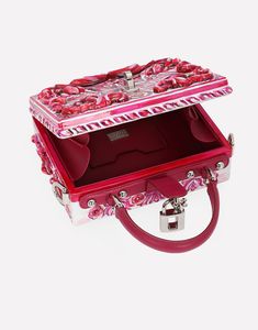 Dolce Box bag in hand-painted resin: Fuchsia Padlock fastening in palladium-electroplated metal with enamel flower embellishment Top handle and adjustable, detachable strap in polished calfskin Calfskin lining and inner pocket with concealed magnetic closure Item comes with special packaging Measurements: H14.5 x W19 x D7 cm Made in Italy The difference in the print placement that you may find on this product is a feature of Dolce & Gabbana’s “Handmade” pieces. A detail that makes every garment or accessory unique and exclusive. Designer Pink Rectangular Case Bag, Luxury Multicolor Box Bag With Detachable Handle, Luxury Silver Box Bag, Luxury Pink Box Bag For Gift, Luxury Rectangular Bags For Fashion Events, Designer Pink Box Bag With Detachable Handle, Designer Red Box Bag For Gift, Luxury Red Box Bag For Gift, Designer Pink Box Bag For Evening