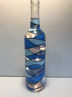 a glass bottle with blue and white designs on the bottom is sitting on a table