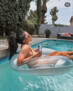 a woman in a pool with a drink