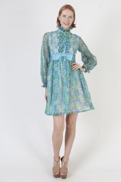 Vintage 60s mod Go-Go scooter mini dress. Tailored bodice with long sheer sleeves and high neckline. Blue all over floral print polyester material. Dress is lined and zips up the back. size estimate: S shoulders: 15" bust: 34" waist: 27" hips: 38" total length: 34.5" Model is 5'9" and measures 32" bust, 25" waist, 34" hips. Belts/accessories are not included unless noted in the description. * Visit the shop * https://www.etsy.com/shop/americanarchive Gogo Outfit, Gogo Outfits, Vintage Scooter, Mod Mini Dress, Material Dress, Outfit Vintage, 60s Mod, 60s Dress, Ruffle Mini Dress