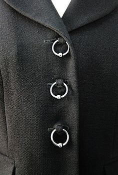 a black suit with three silver rings attached to it