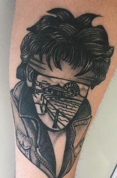 a man's leg with a tattoo on it that has an image of a person wearing a mask