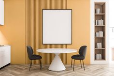 a white table with two black chairs in front of an empty poster on the wall