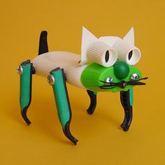 a green and white cat shaped hair dryer with two cats on it's back