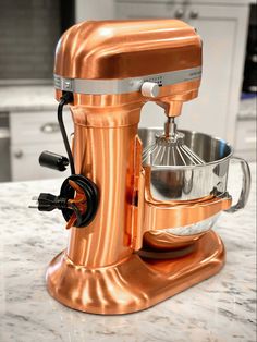 an orange mixer sitting on top of a kitchen counter