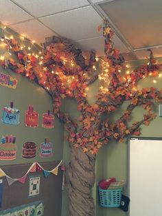 a tree is decorated with fall leaves and lights