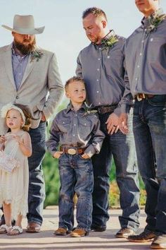 a group of people standing next to each other wearing cowboy hats and holding flowers in their hands