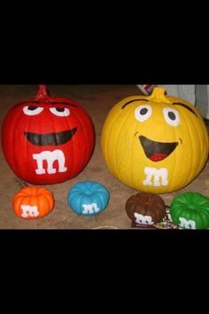 two pumpkins with faces painted on them sitting next to each other in the shape of m and m