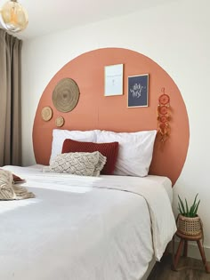 a bed with white linens and pillows in a small room next to a window