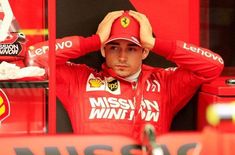 a man sitting in the drivers seat of a race car with his hands on his head