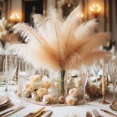 a centerpiece with feathers and flowers on a table at a wedding reception in an elegant setting