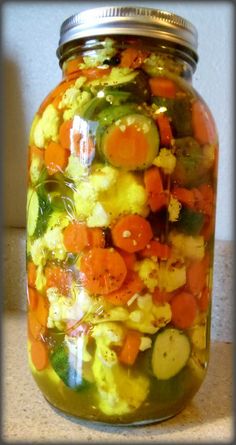 a jar filled with vegetables sitting on top of a counter