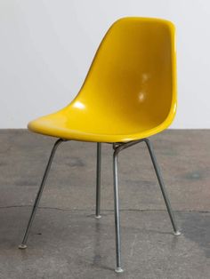 a yellow chair sitting on top of a cement floor