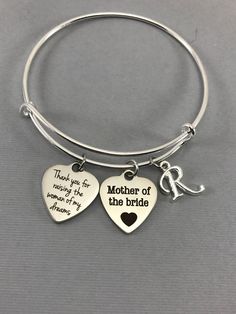 mother of the bride bracelet with two heart shaped charms and a keychain attached to it