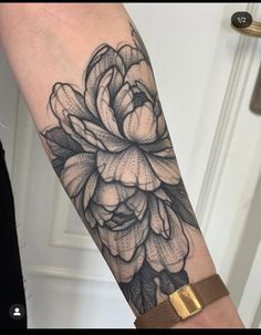 a black and white flower tattoo on the arm