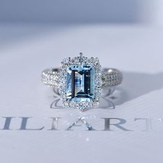 a ring with an aqua blue diamond surrounded by diamonds