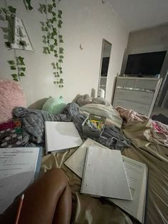 an unmade bed with books and papers on it