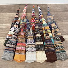 a pile of multicolored socks sitting on top of a wooden floor next to each other