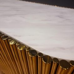 a close up view of a white marble counter top with gold metal circles on it