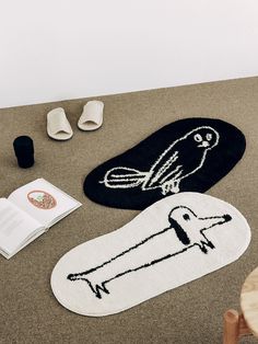 the rugs are laid out on the floor next to shoes and an open book