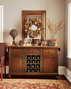 a dining room table with wine glasses on it and a mirror over the buffet area