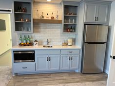 a kitchen with gray cabinets and stainless steel appliances