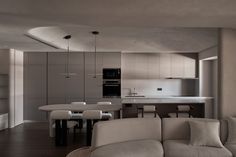 a living room filled with furniture next to a kitchen