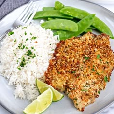 a white plate topped with rice and green beans next to meat covered in seasoning