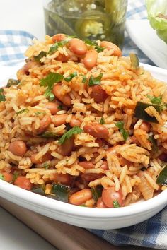 a white bowl filled with rice and beans on top of a blue checkered table cloth