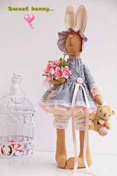 there is a stuffed rabbit holding flowers and a teddy bear next to a birdcage