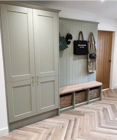 an empty entryway with wooden flooring and storage units on either side of it