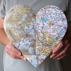 a person holding a heart shaped map with the shape of a heart in front of them