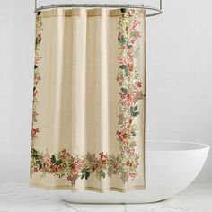 a shower curtain with flowers and leaves on it in a white bathtub next to a toilet