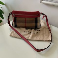 Authentic Burberry Check And Leather Bag In Red. Purchased This Bag In Nyc. Authentication Code Is Shown In The Photos. This Bag Is Worn But In Good Condition. Flaws In The Bottom Corners Of The Bag As Shown In The Photos Red Bucket Shoulder Bag With Gold-tone Hardware, Red Burberry Purse, Burberry Clutch Bag, Red Rectangular Bucket Bag With Gold-tone Hardware, Burberry Check Tote Bag, Burberry Bag, Leather Bag, Burberry, Bag Lady