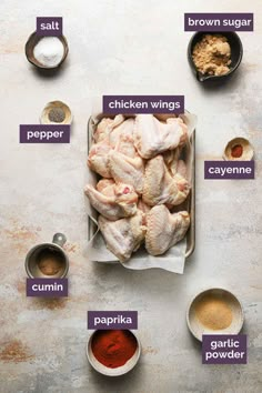 the ingredients for chicken wings laid out on a table with their names in purple and white