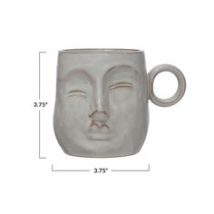 a white ceramic mug with a face on the front and side of it's cup