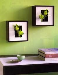 two framed pictures on the wall above a table with a cup and book next to it