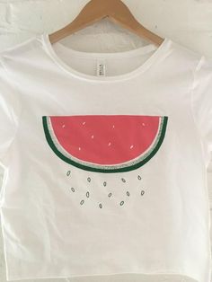 Hand Drawn and Hand Printed! This is a screen printed crop top with a hand drawn watermelon with falling seeds! It's perfect for summer! The shirt shown here is white and is printed in red and green ink. These are more of a juniors' sized fit! // PROCESS: All of our items are individually hand printed by either me or my dad, which can lead to slight variations in placement. The ink is heat cured and will not fade over time. Since our items are printed to order, there is a 1-2 week processing tim Summer Graphic Tee Crop Top With Screen Print, Pink Fruit Print T-shirt For Summer, Summer Watermelon Cotton Tops, Cute Summer Crop Top With Funny Print, Summer Screen Print Crew Neck Crop Top, Summer Crew Neck Crop Top With Screen Print, Fun Watermelon Colored Tops For Summer, Fun Watermelon Color Tops For Summer, Fun Watermelon Color Summer Tops