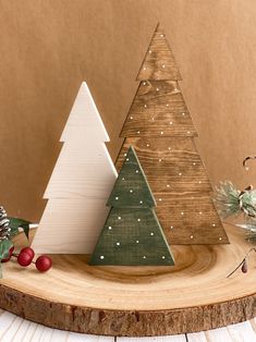 three wooden christmas trees sitting on top of a table