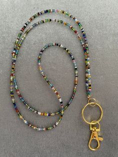 a beaded lanyard with a pair of gold scissors on it and a keychain