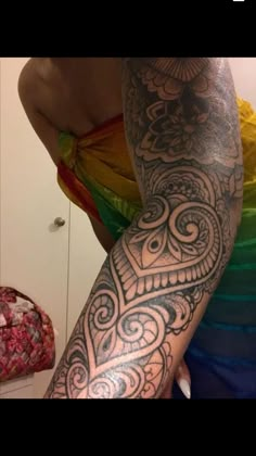 a woman's arm with an intricate tattoo design on her left arm and shoulder