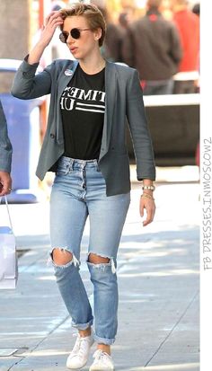 a woman walking down the street in ripped jeans