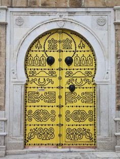 a yellow door with ornate designs on it