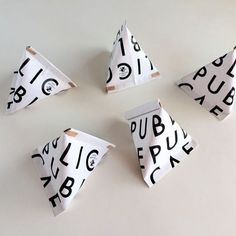 four pieces of paper with black and white letters on them are arranged in the shape of triangulars