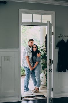 a man and woman standing in front of a door with their arms around each other