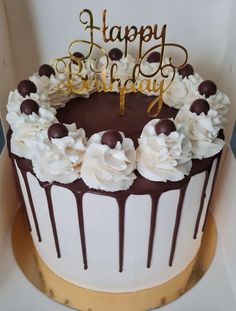 a birthday cake with white frosting and chocolate decorations