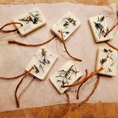 four soaps with dried herbs on them are tied up and ready to be used